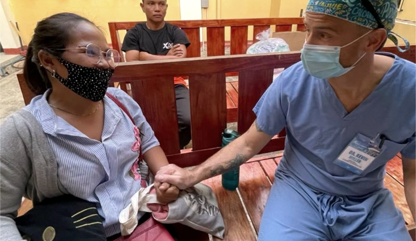 Podiatrist Dr. Miller sits with the mother of a patient during his medical mission to the Philippines.