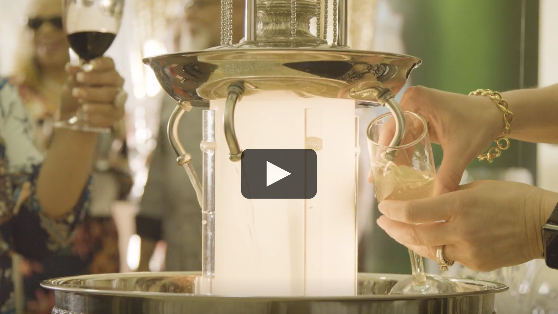 Two individuals using a champagne fountain in the VIP lounge at the Wine, Brew & Food Jubilee event.